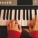 a person is playing the piano with their hands and fingers on top of it's keyboard