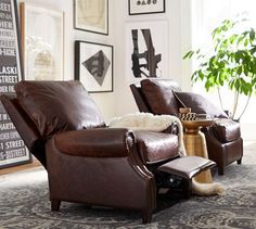 two leather recliners in a living room with pictures on the wall