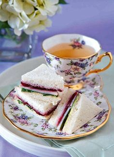 a plate with sandwiches and a cup of tea