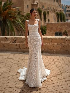 a woman in a wedding dress standing on a brick walkway