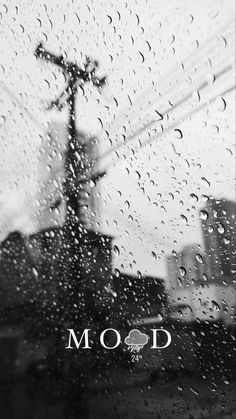 black and white photograph of raindrops on a window with the word mood written across it