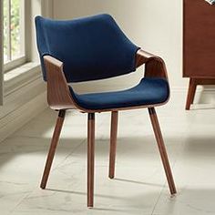 a blue chair sitting on top of a white tile floor next to a wooden table