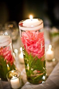 candles and flowers in glass vases on a table