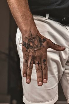 a man's hand with tattoos on it