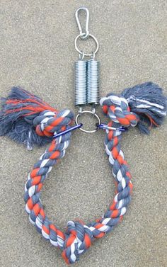 an orange, white and blue rope is attached to a metal hook on the ground