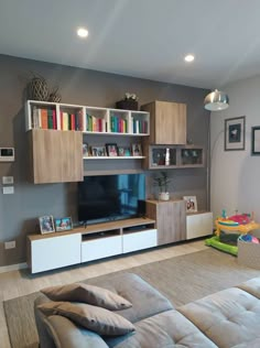 a living room filled with furniture and a flat screen tv on top of a wooden entertainment center