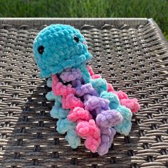 a crocheted stuffed animal sitting on top of a wicker table