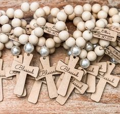 several wooden beads with names on them are laid out in the shape of crosses and pearls