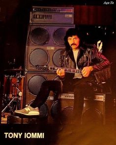 a man sitting on top of a chair holding a guitar