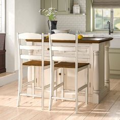 a kitchen with white cabinets and wooden floors