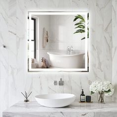 a bathroom with a sink, mirror and bathtub on the counter in front of it