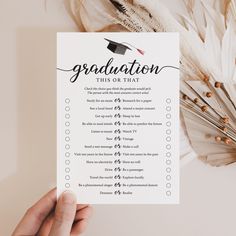 a hand holding up a graduation checklist with feathers around it and the words, graduation this is on that list