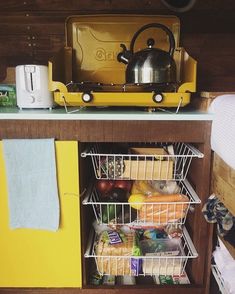 an open refrigerator with food in it next to a tea kettle