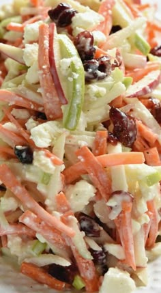 a salad with carrots, celery and raisins on a white plate