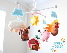 several stuffed animals hanging from the ceiling in a child's playroom with clouds and stars above them