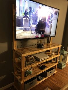 a flat screen tv sitting on top of a wooden shelf