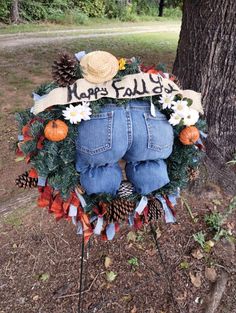 a wreath made to look like jeans and pine cones with the words happy fall written on it