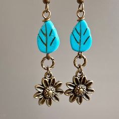 "Sunflower Earrings - Brass plated Sunflowers dangle from Turquoise Czech Glass Leaf Beads and Twisted Antiqued Brass plated Rings. Antiqued Brass Earwires Earrings measure j2.25\" from top of earwire to bottom of flowers." Adjustable Dangle Earrings With Flower Charm, Nature-inspired Drop Flower Earrings For Pierced Ears, Bohemian Dangle Earrings With Flower Charm, Vintage Dangle Earrings With Flower Charm, Bohemian Hypoallergenic Flower Earrings, Turquoise Flower-shaped Earrings With Flower Charm, Bohemian Flower Charm Drop Earrings, Turquoise Earrings With Flower Charm, Nature-inspired Hypoallergenic Flower Drop Earrings