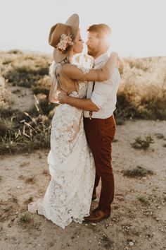 a bride and groom embracing in the desert