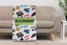 a blanket that is sitting on the floor in front of a couch with video game controllers