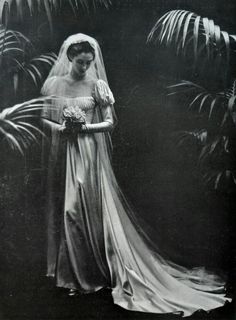 an old black and white photo of a woman in a wedding dress