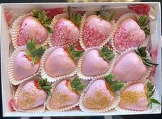 a box filled with lots of pink and gold covered strawberries