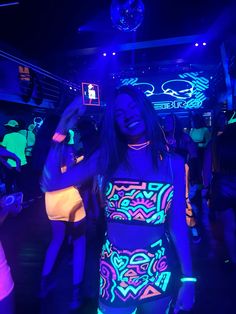 a woman standing in front of a disco ball with her cell phone up to her ear