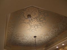 the ceiling is decorated with an intricate pattern and lightshade above it, along with a chandelier