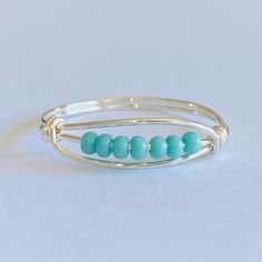 Made with Turquoise glass seed beads Comes with approximately 6 beads unless you specify a different quantity The band is tarnish-resistant plated wire in your choice of finish Turquoise Beaded Rings As Gifts, Turquoise Beaded Rings As A Gift, Everyday Turquoise Jewelry With Spacer Beads, Adjustable Nickel-free Blue Stackable Rings, Ring With Gold Band, Worry Ring, Jasper Ring, Green Jasper, Fidget Rings