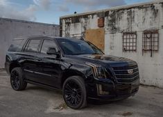 a black suv parked in front of an old building