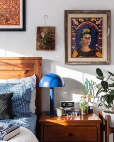 a bed room with a neatly made bed and pictures on the wall