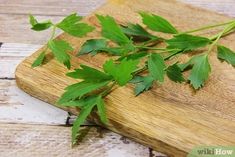 some green leaves are laying on a cutting board