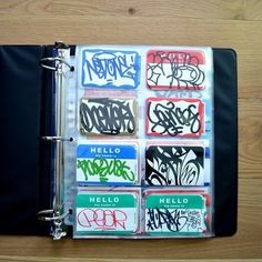 an open notebook covered in graffiti on top of a wooden table next to a clipboard