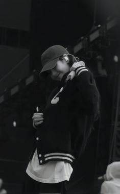 black and white photograph of a person wearing a baseball cap with his hand on his hip