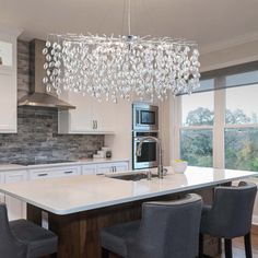 a modern kitchen with an island and chandelier