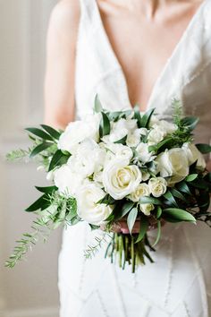 a bride holding a bouquet of white flowers