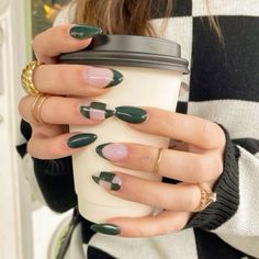 a woman holding a coffee cup with green nail polish