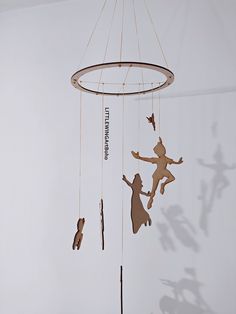 the shadow of two children playing on a wind chime