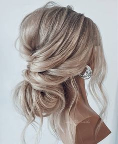 a woman with blonde hair in a half updo, wearing an elegant hairstyle