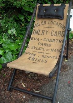 an old chair is sitting on the side of the road in front of some bushes