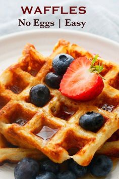 waffles with blueberries and strawberries on a white plate