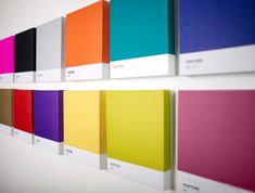 a row of different colored books on a wall