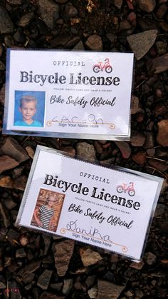 two business cards laying on top of some rocks next to each other with the name bicycle license