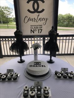 a table topped with a white cake and lots of cupcakes on top of it