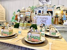 there is a table set up for a children's birthday party with cakes and decorations