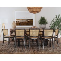 a dining room table and chairs in front of a painting