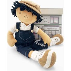 a small stuffed doll sitting in front of a post office with the word frankie written on it