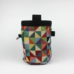 a multicolored bag with a black handle on the side and a white background