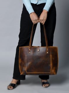 Step out in style with our handcrafted Buffalo Terry Tote. Made from luxurious Buffalo leather, this plain tote boasts a modern look and finish, perfect for your daily needs. Elevate any outfit with this sophisticated and exclusive accessory. Coffee Brown color Handcrafted & made of buffalo leather Top Handle and inside pocket Lightweight & durable leather Size in Inch 15W x 11H x 4 D Inch Size in Cm 38.1W x 27.94H x 10.16D Cm Classic Distressed Brown Bag For Everyday Use, Modern Brown Shoulder Bag With Waxed Finish, Modern Brown Bags With Waxed Finish, Distressed Brown Bags For Everyday Use, Luxury Bags With Waxed Finish For Everyday Use, Luxury Oiled Leather Everyday Bag, Luxury Everyday Oiled Leather Bag, Classic Tote Shoulder Bag With Waxed Finish, Classic Everyday Shoulder Bag In Oiled Leather