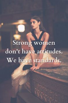 a woman sitting on top of a table with her legs crossed and the words strong women don't have attributes we have standards